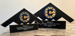 Two triangular military achievement awards with circular emblems by Elite Metalworking