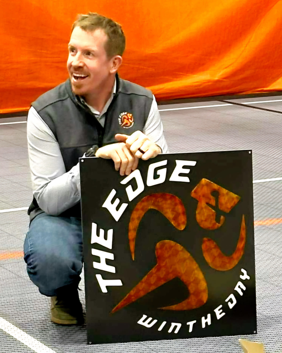 Black, white and orange custom metal gym logo sign for The Edge at a training facility