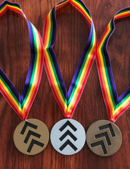 Round metal medals with geometric emblems by Elite Metalworking