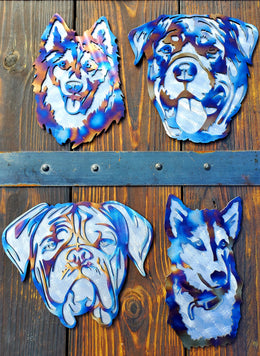 Four finished dog portrait metal pieces displayed on a fence by Elite Metalworking