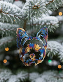 A decorative metal ornament in the shape of an Avon Terrier dog with a multicolored finish, hanging from a black string.