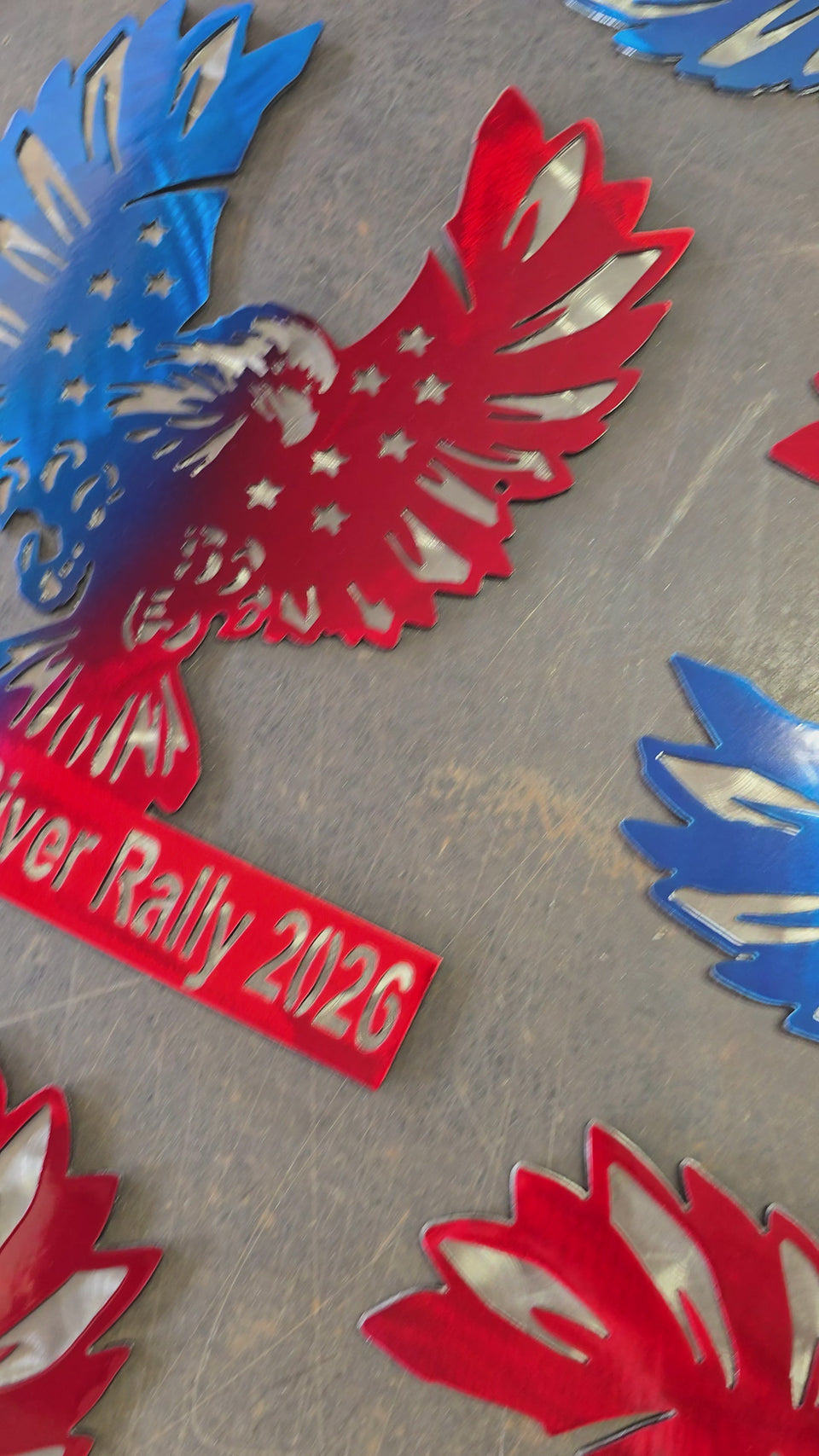 Red and blue winged metal awards displayed together by Elite Metalworking